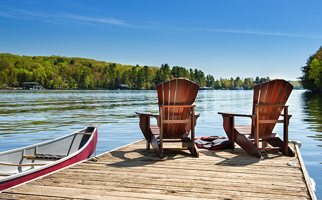 Two Adirondack chairs on a dock